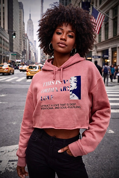 Woman wearing a pink hoodie with text and graphics on a city street
